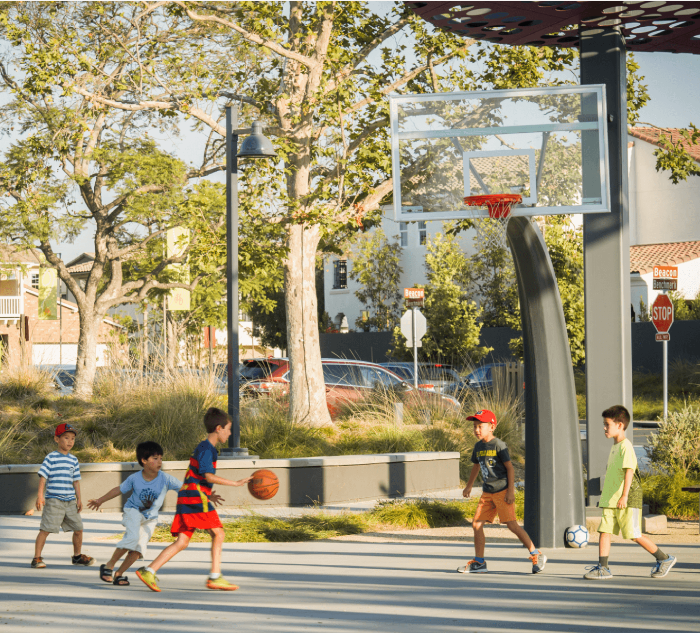 Kids playing basketball at a park.